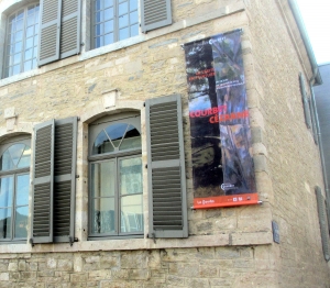 L'affiche de l'exposition fixé sur le musée Courbet à Ornans